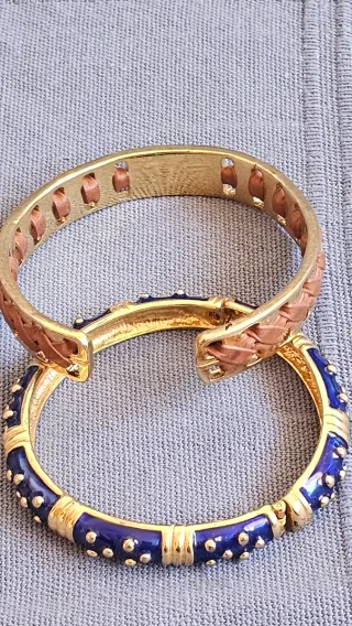 Dos pulseras doradas con detalles azules