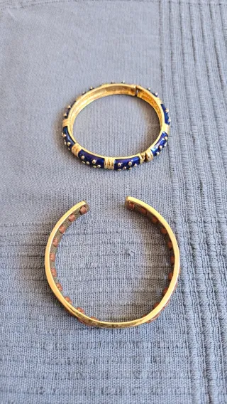 Dos pulseras doradas con detalles azules