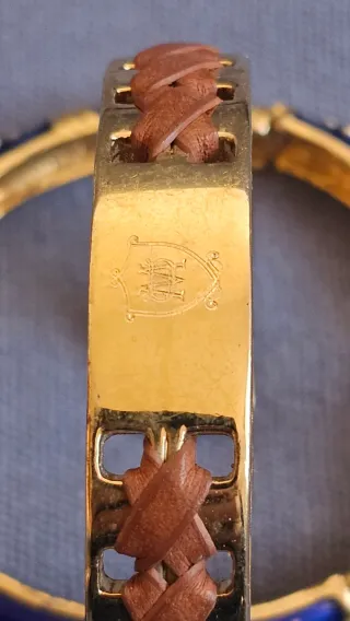 Dos pulseras doradas con detalles azules