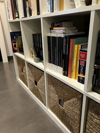 Estantería de madera con cajones de mimbre.