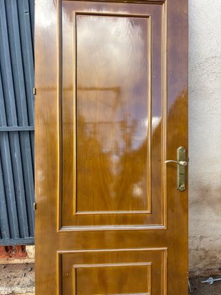 Puerta de madera con manilla dorada