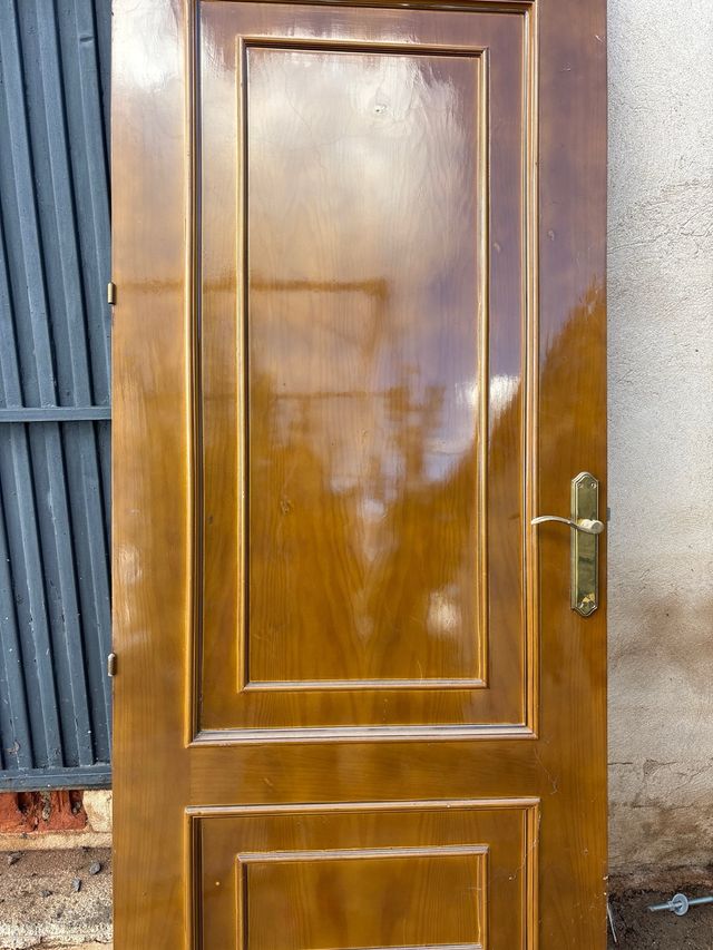 Puerta de madera con manilla dorada