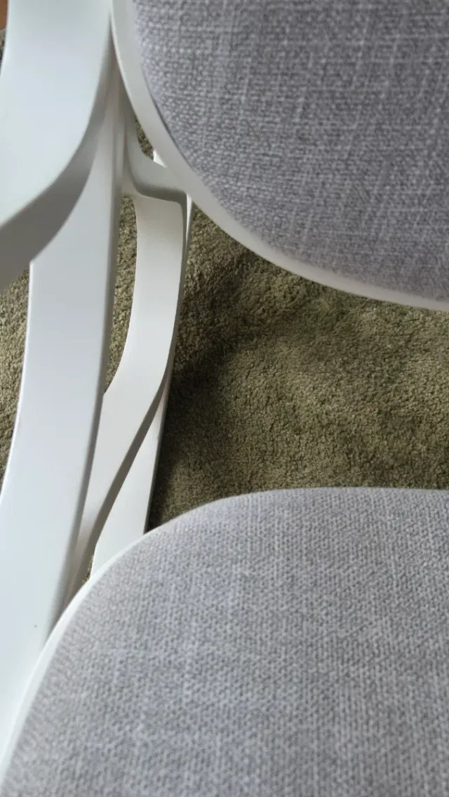 Mecedora de madera blanca tapizada en gris