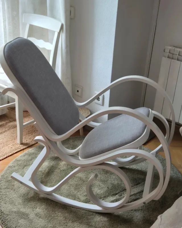 Mecedora de madera blanca tapizada en gris