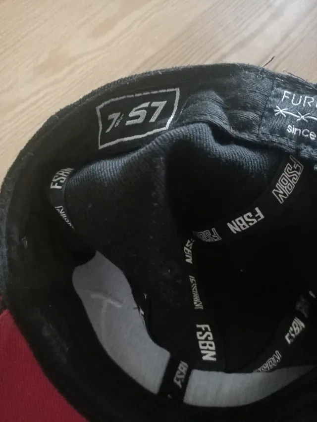Gorra negra y roja con diseño de cara sonriente