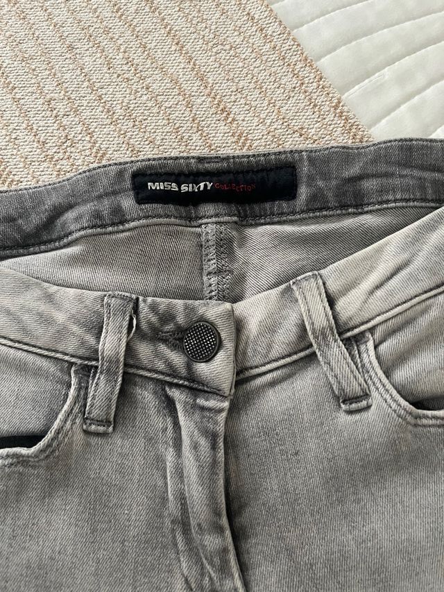 Pantalón gris con tachuelas.