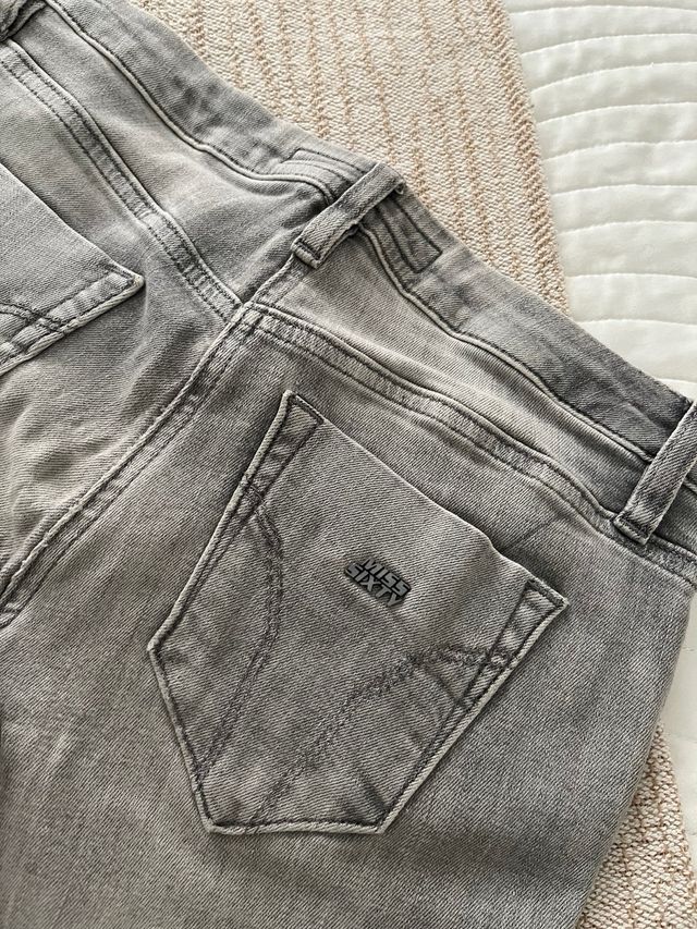 Pantalón gris con tachuelas.