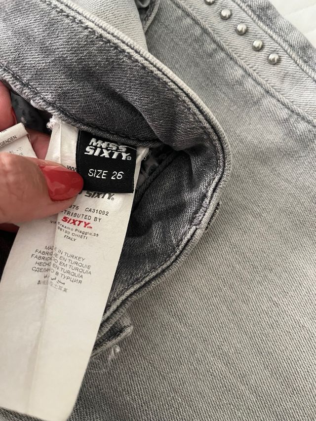 Pantalón gris con tachuelas.