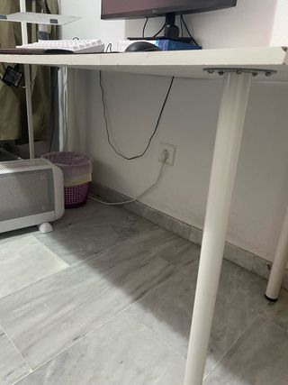 Escritorio blanco con tablero y patas.