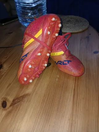 Botas de fútbol naranjas y rojas