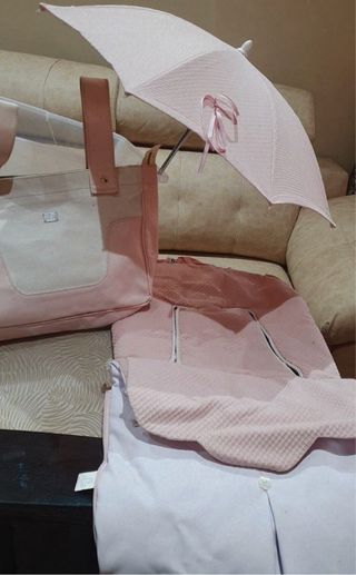 Funda y sombrilla para cochecito color rosa.