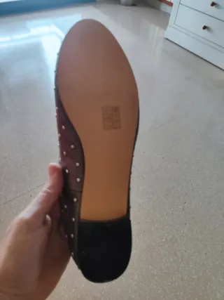 Zapatos planos plateados con tachuelas.