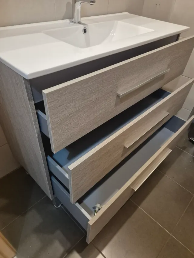 Mueble de baño gris con tiradores plateados