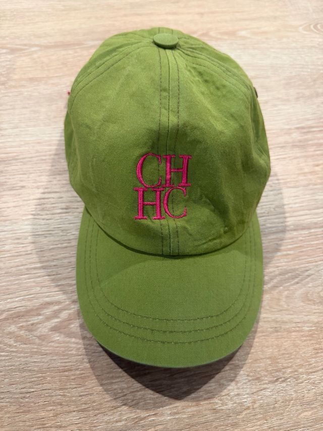 Gorra Carolina Herrera verde con detalles rosas.