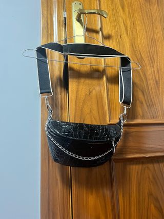 Riñonera negra efecto piel con cadena.