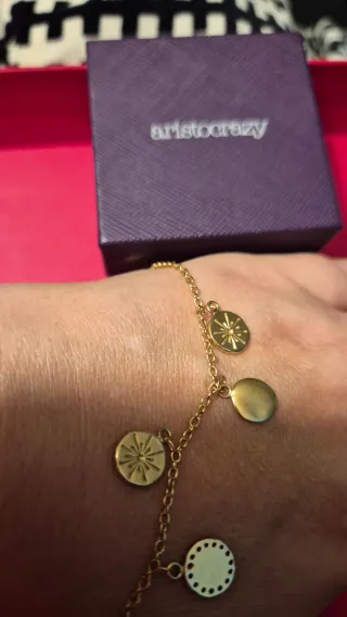 Pulsera Aristocrazy dorada con dijes de plata