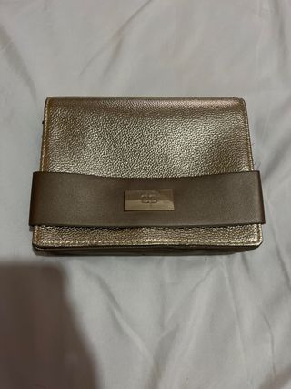 Bolso de mano dorado con detalle de lazo