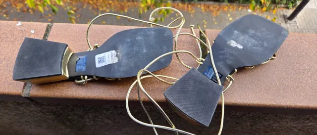 Sandalias doradas con tiras negras