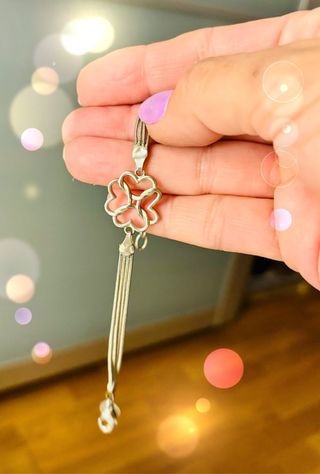 Pulsera plateada con diseño floral.