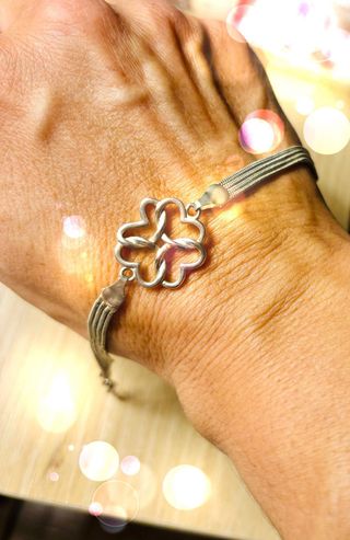 Pulsera plateada con diseño floral.