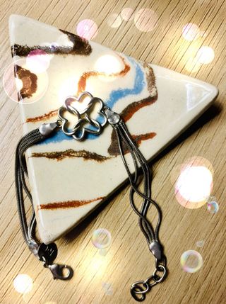 Pulsera plateada con diseño floral.