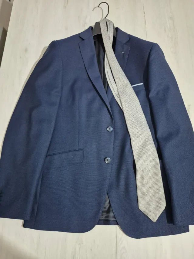 Traje azul y corbata plateada