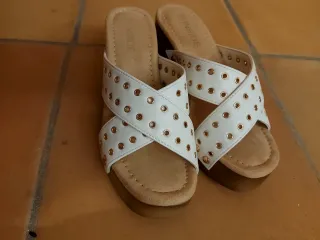 Sandalias blancas con tachuelas doradas