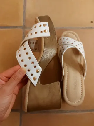Sandalias blancas con tachuelas doradas