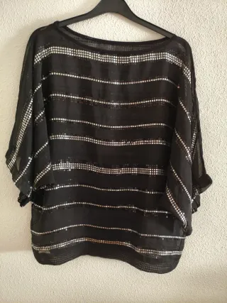 Blusa negra de gasa con lentejuelas plateadas.