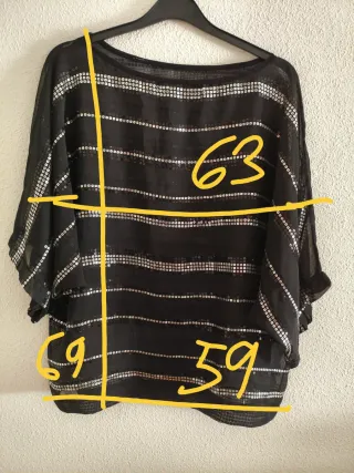 Blusa negra de gasa con lentejuelas plateadas.