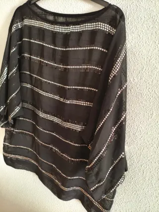 Blusa negra de gasa con lentejuelas plateadas.