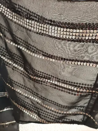 Blusa negra de gasa con lentejuelas plateadas.