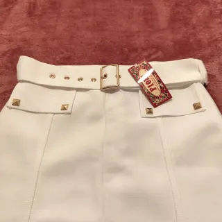 Falda blanca con cinturón y tachuelas
