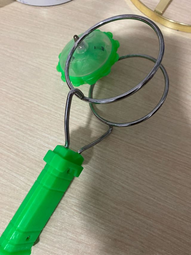 Juguete giratorio verde con aros