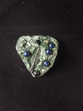 Amuleto de la suerte con pluma y bayas