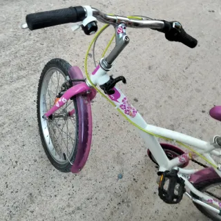 Bicicleta infantil rosa y blanca con ruedines