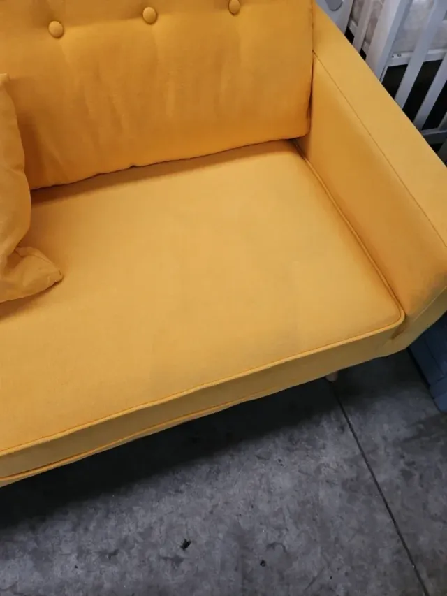 Sofá amarillo de tela con cojines