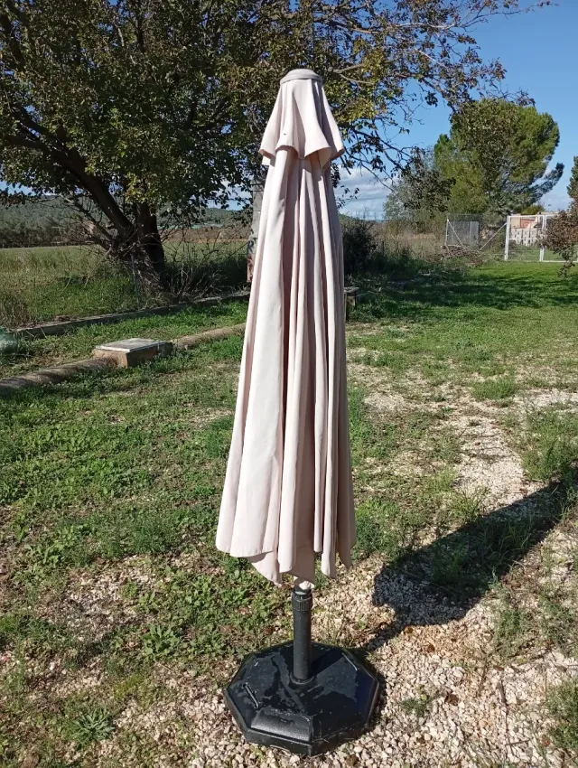 Sombrilla beige con pie de hormigón