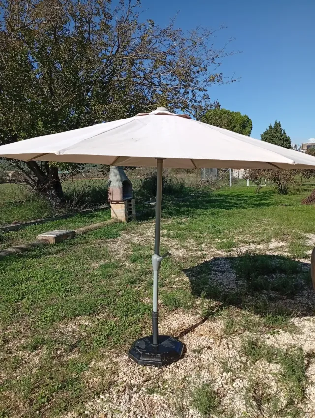 Sombrilla beige con pie de hormigón