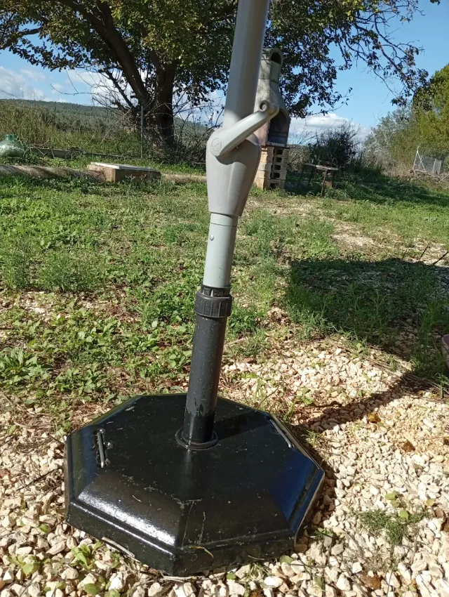 Sombrilla beige con pie de hormigón