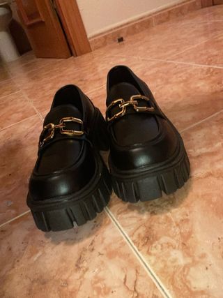 Zapatos negros con hebilla dorada