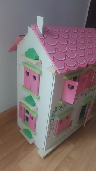 Casa de muñecas rosa con muebles