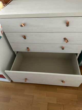 Cómoda de madera con tiradores de cuero.