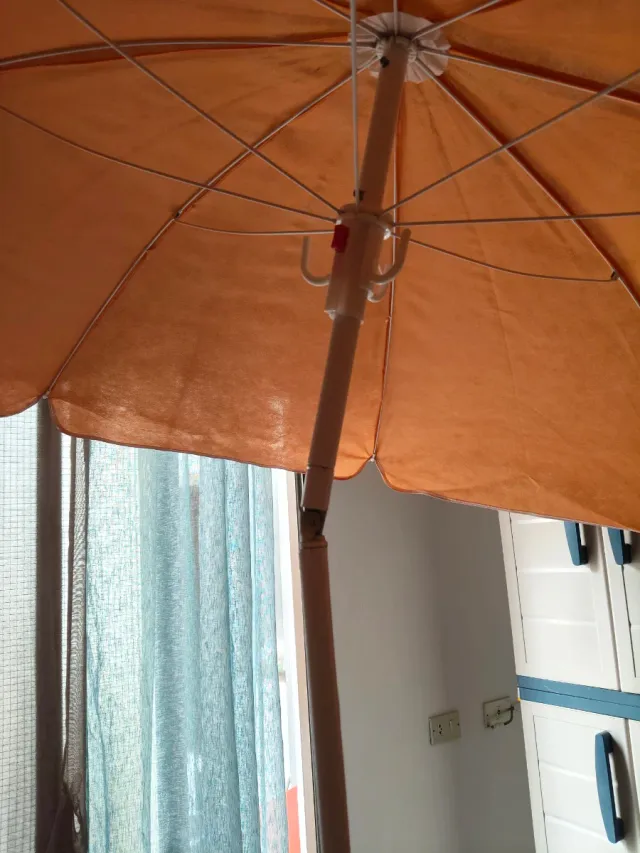 Sombrilla naranja/amarilla con base plegable