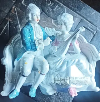 Pareja de porcelana sentada en banco