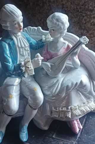 Pareja de porcelana sentada en banco