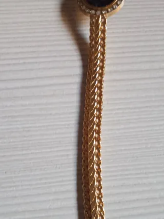 Pulsera dorada con moneda y piedrecitas