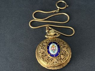 Reloj de bolsillo dorado con cadena