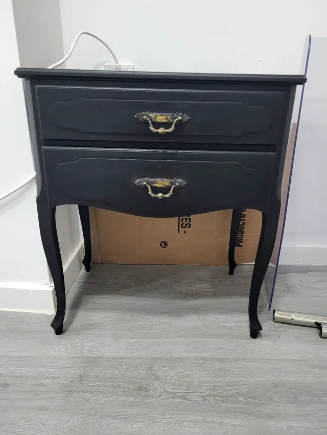 Mesita de noche negra con detalles dorados