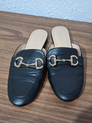 Mocasines negros con hebilla dorada